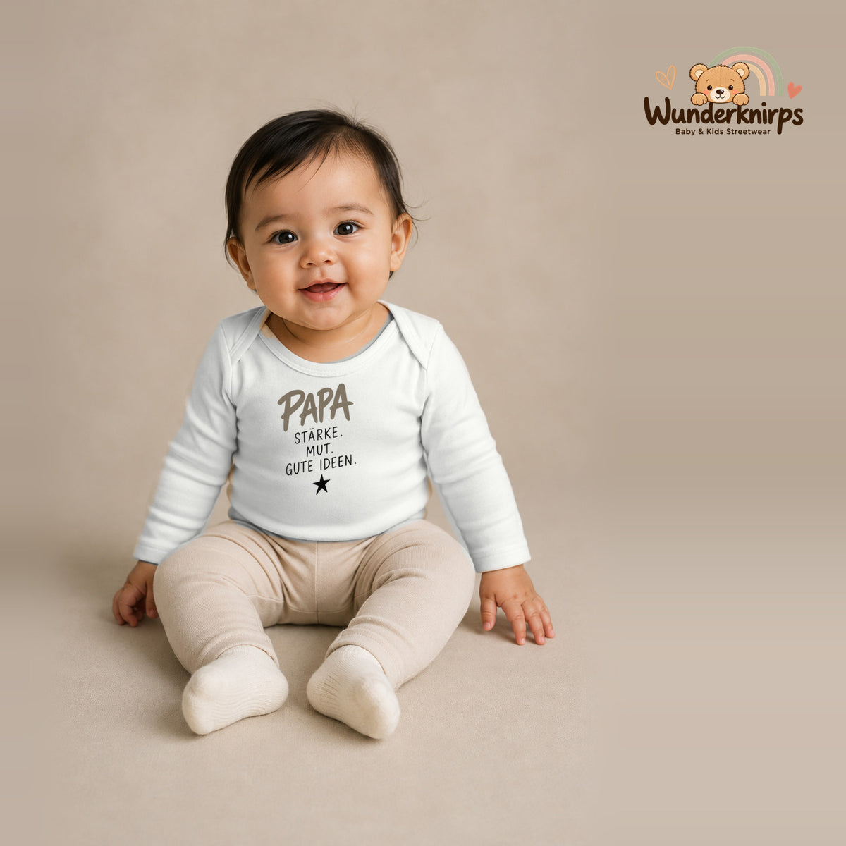 Babybody für Mädchen in Weiß mit Motiv „Papa Stärke“, getragen von einem Kind – Wunderknirps.