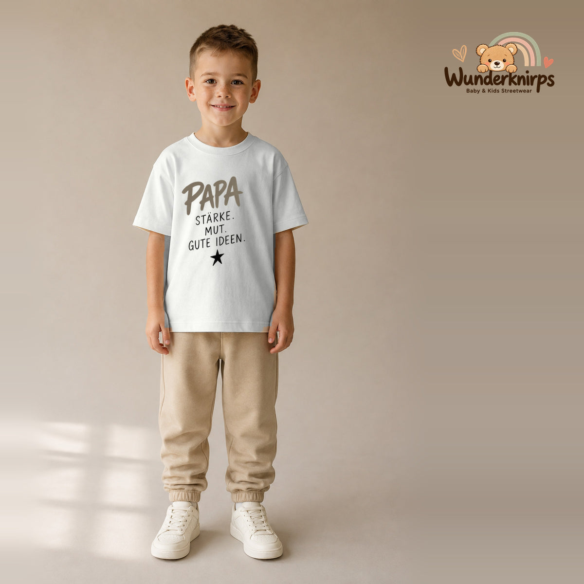 T-Shirt für Jungen in Weiß mit Motiv „Papa Stärke“, getragen von einem Kind – Wunderknirps.