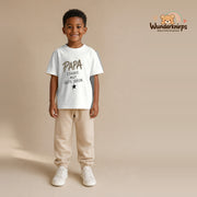 T-Shirt für Jungen in Weiß mit Motiv „Papa Stärke“, getragen von einem Kind – Wunderknirps.
