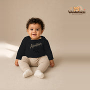 Babybody für Jungen in Schwarz mit Motiv „Papas Abenteuer“, getragen von einem Kind – Wunderknirps.