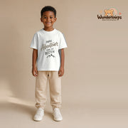T-Shirt für Jungen in Weiß mit Motiv „Papas Abenteuer“, getragen von einem Kind – Wunderknirps.