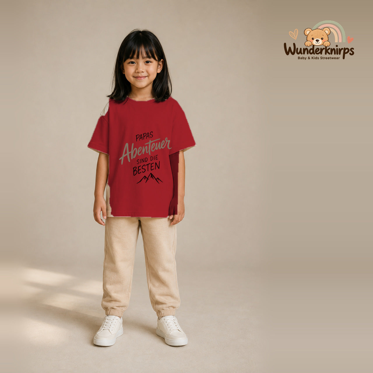 T-Shirt für Mädchen in Rot mit Motiv „Papas Abenteuer“, getragen von einem Kind – Wunderknirps.