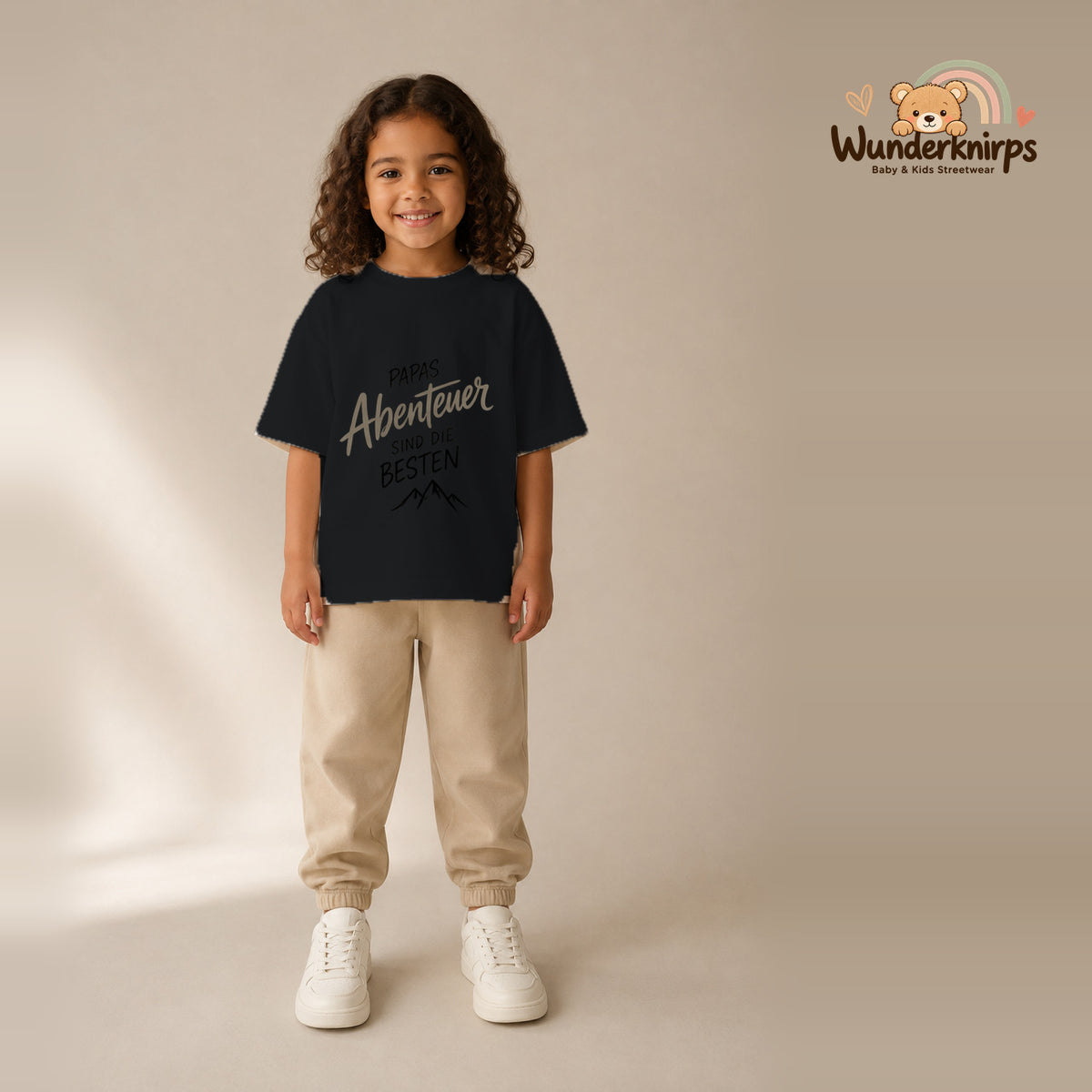 T-Shirt für Mädchen in Schwarz mit Motiv „Papas Abenteuer“, getragen von einem Kind – Wunderknirps.