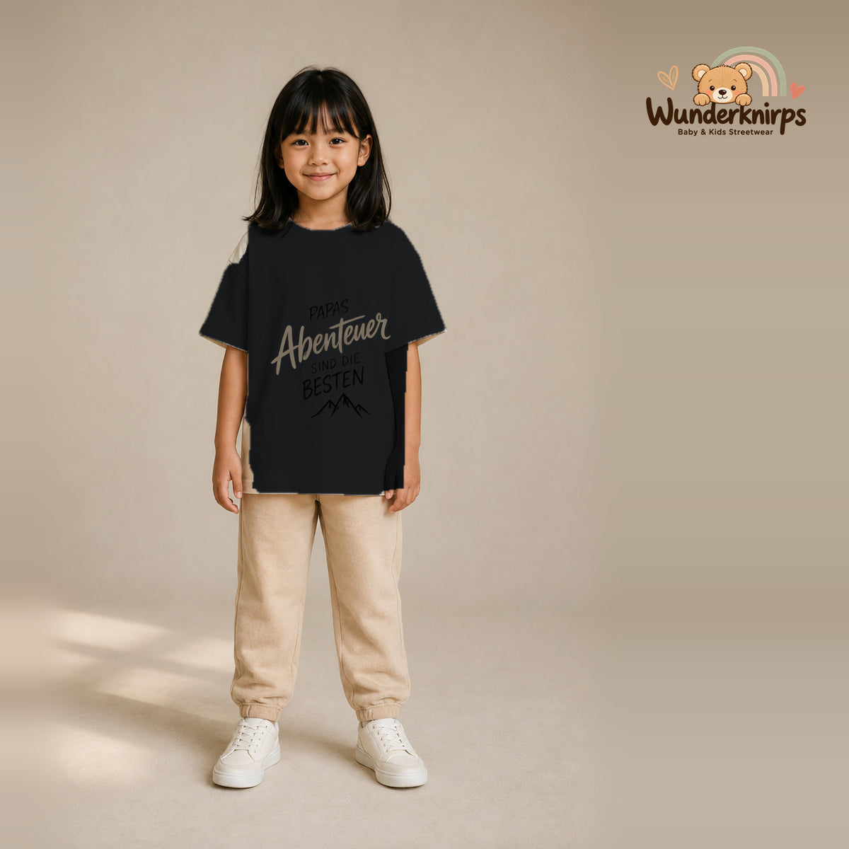 T-Shirt für Mädchen in Schwarz mit Motiv „Papas Abenteuer“, getragen von einem Kind – Wunderknirps.