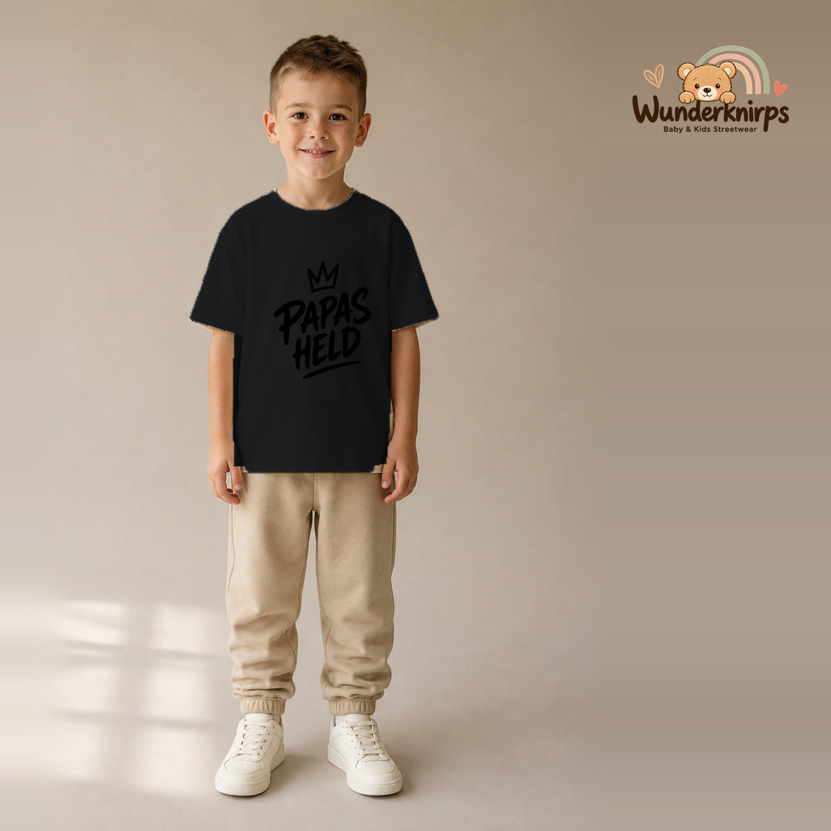 T-Shirt für Jungen in Schwarz mit Motiv „Papas Held“, getragen von einem Kind – Wunderknirps.