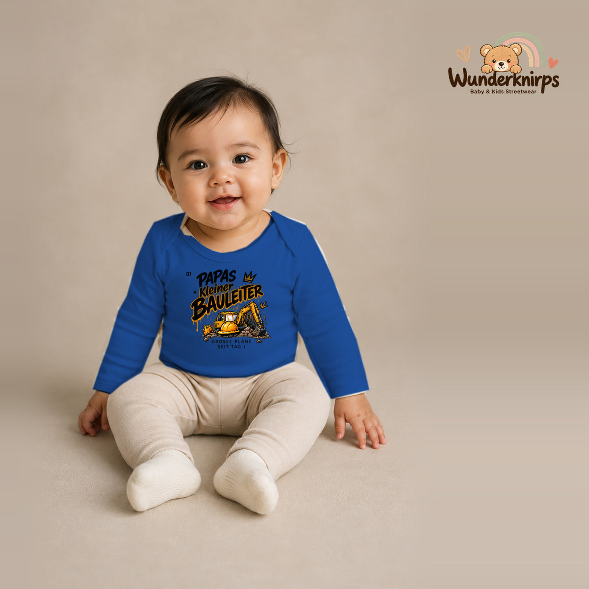 Babybody für Mädchen in Blau mit Motiv „Papas kleiner Bauleiter“, getragen von einem Kind – Wunderknirps.