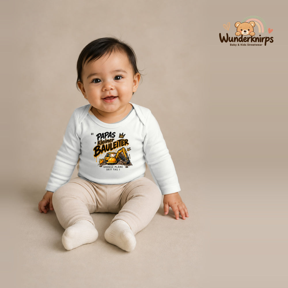 Babybody für Mädchen in Weiß mit Motiv „Papas kleiner Bauleiter“, getragen von einem Kind – Wunderknirps.