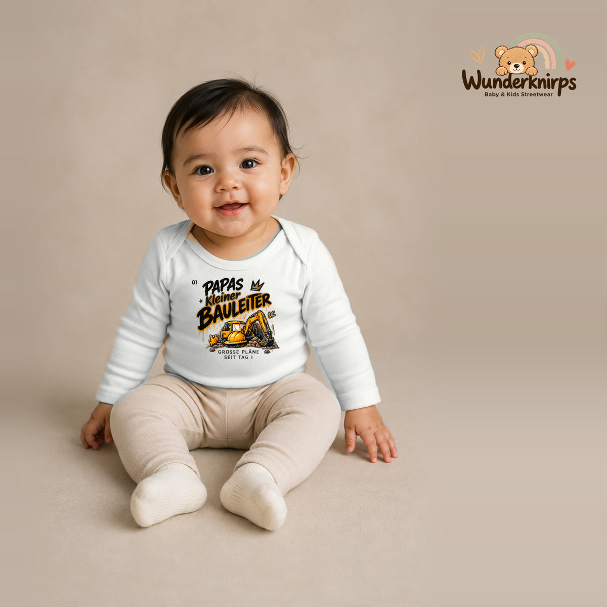 Babybody für Mädchen in Weiß mit Motiv „Papas kleiner Bauleiter“, getragen von einem Kind – Wunderknirps.