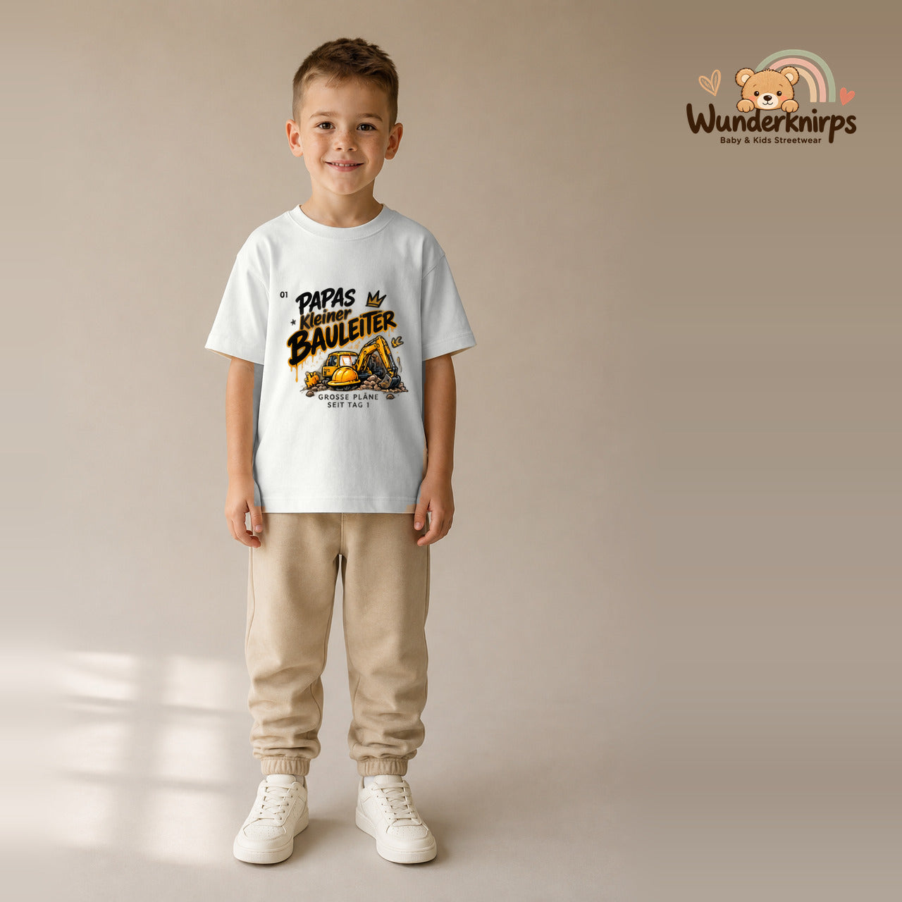 T-Shirt für Jungen in Weiß mit Motiv „Papas kleiner Bauleiter“, getragen von einem Kind – Wunderknirps.