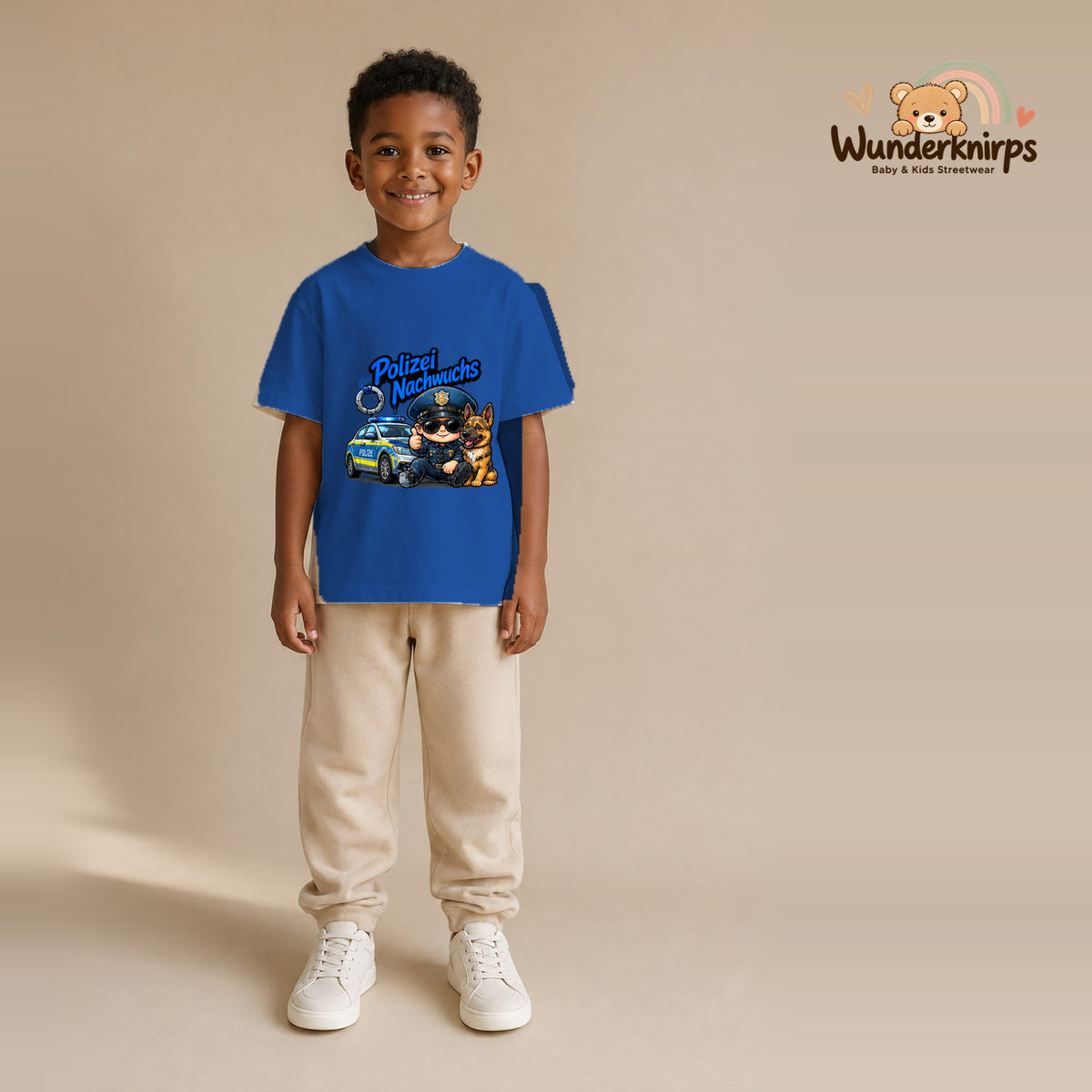 T-Shirt für Jungen in Blau mit Motiv „Polizei Nachwuchs“, getragen von einem Kind – Wunderknirps.