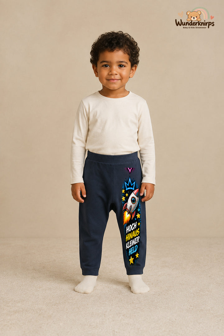 Rakete Alltagsheld – Hoch hinaus kleiner held – Babyhose für Jungen: Navy mit Rakete-Druck am Hosenbein – Wunderknirps.