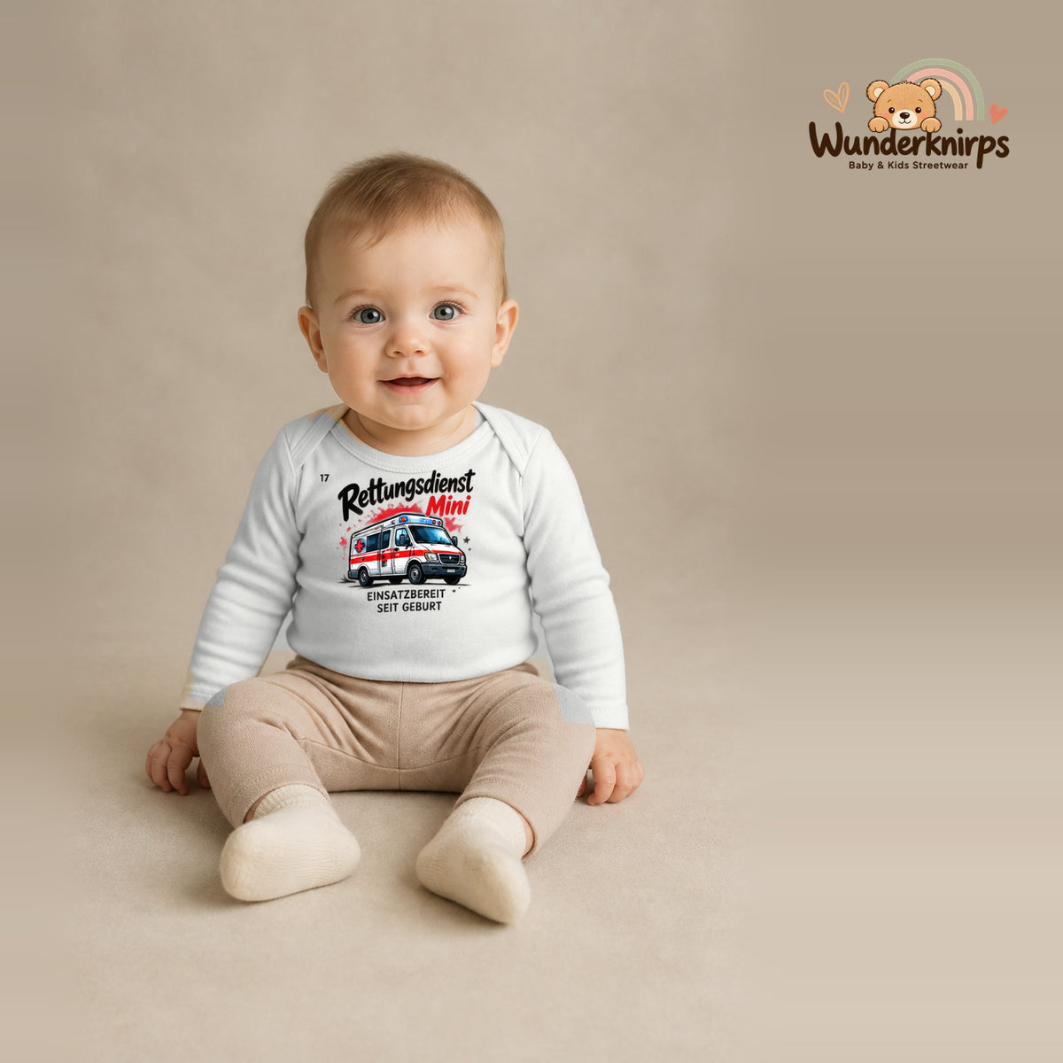 Babybody für Jungen in Weiß mit Motiv „Rettungsdienst Mini“, getragen von einem Kind – Wunderknirps.
