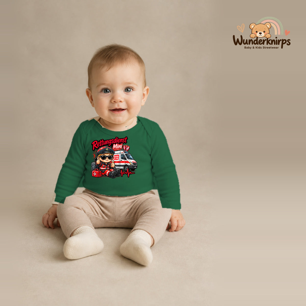 Babybody für Jungen in Grün mit Motiv „Rettungsdienst Mini“, getragen von einem Kind – Wunderknirps.