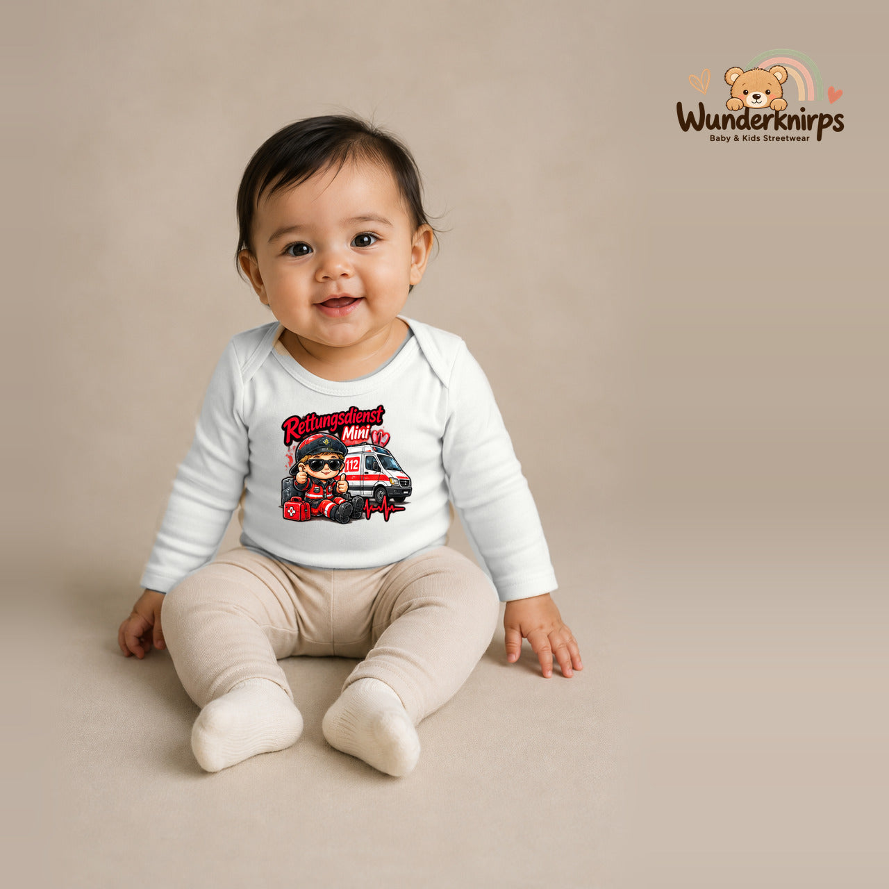 Babybody für Mädchen in Weiß mit Motiv „Rettungsdienst Mini“, getragen von einem Kind – Wunderknirps.