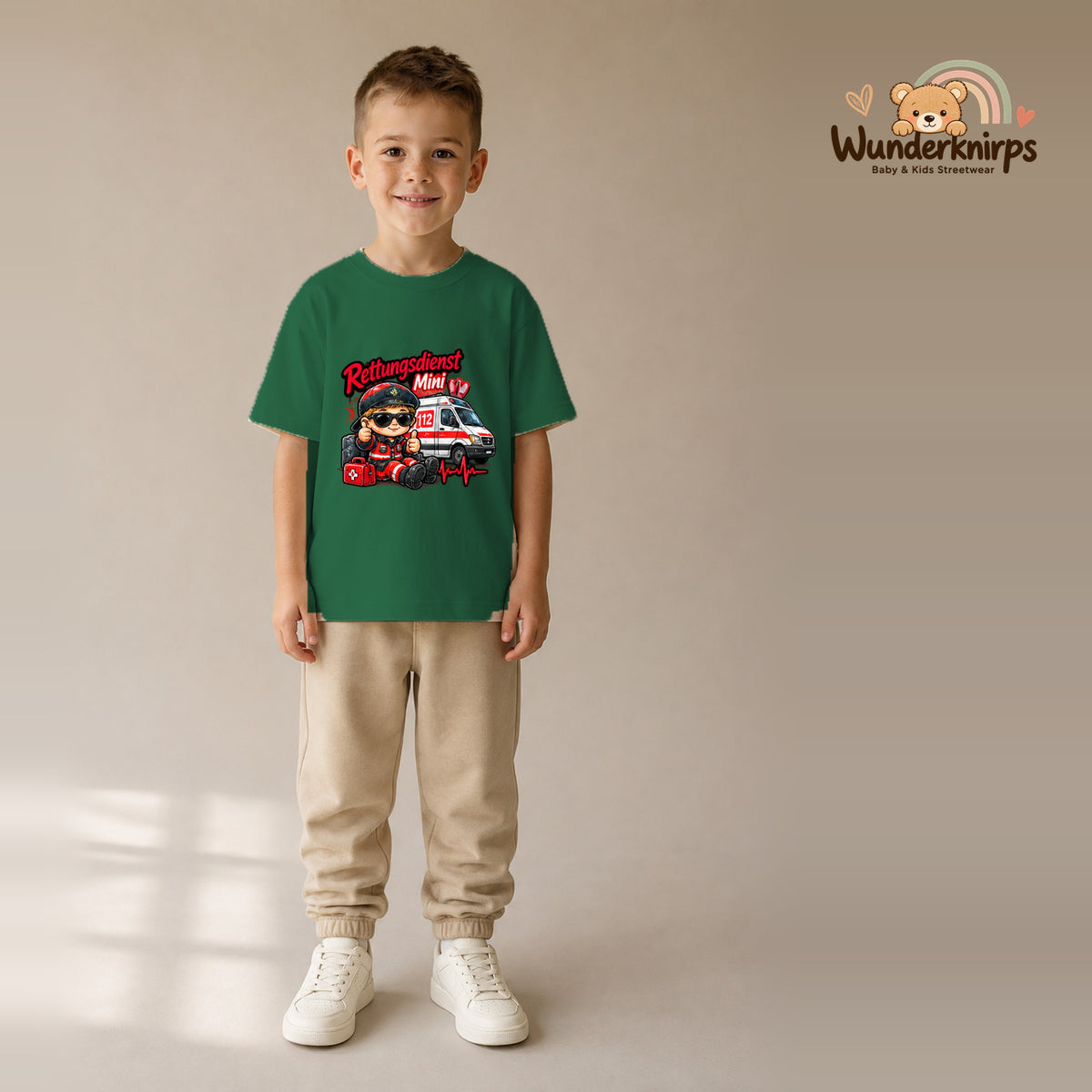 T-Shirt für Jungen in Grün mit Motiv „Rettungsdienst Mini“, getragen von einem Kind – Wunderknirps.