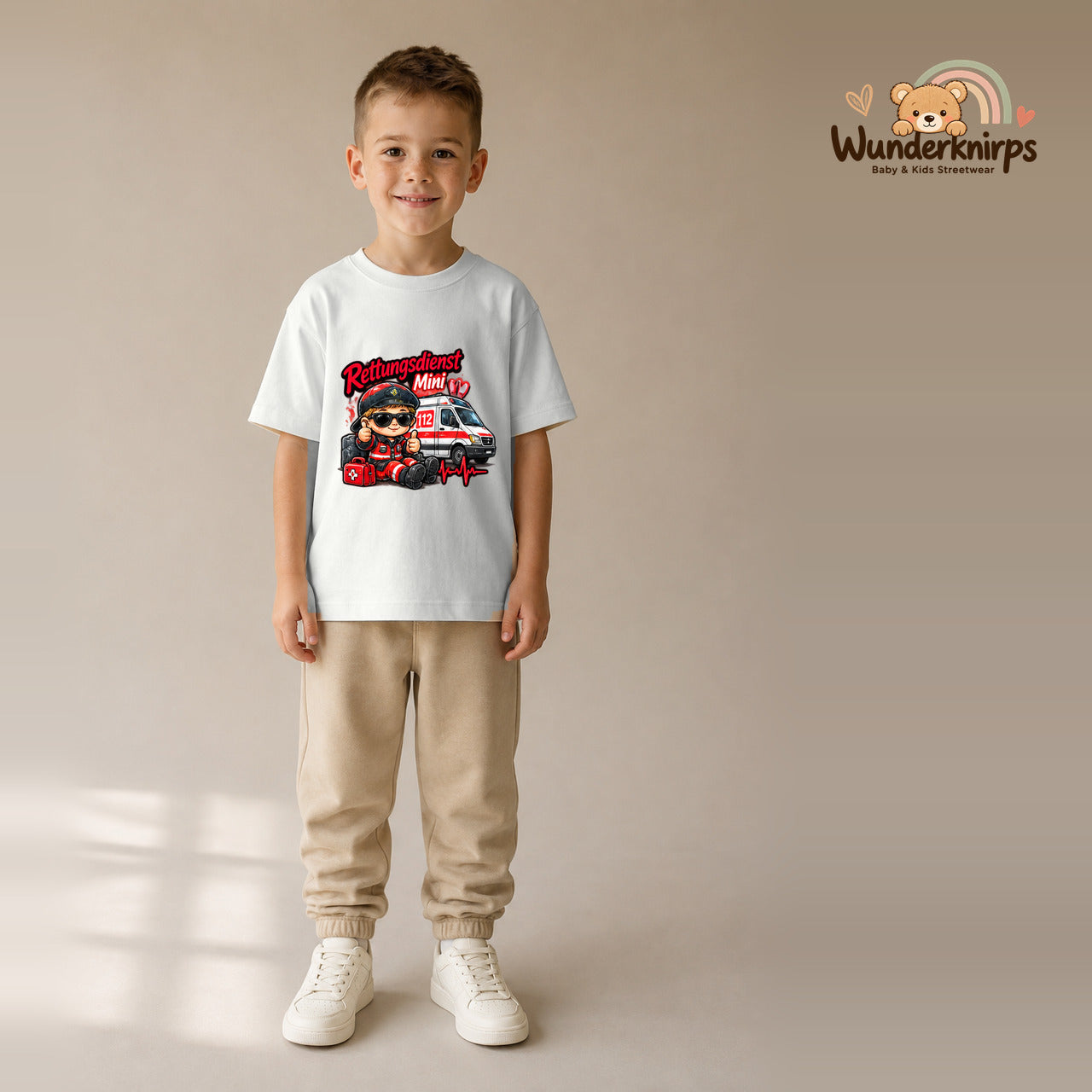 T-Shirt für Jungen in Weiß mit Motiv „Rettungsdienst Mini“, getragen von einem Kind – Wunderknirps.