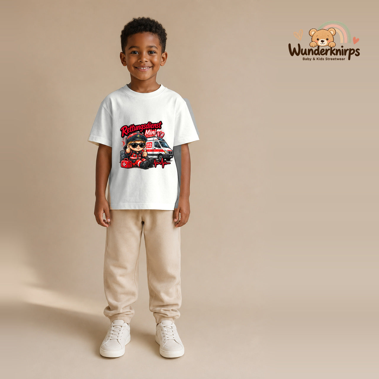 T-Shirt für Jungen in Weiß mit Motiv „Rettungsdienst Mini“, getragen von einem Kind – Wunderknirps.
