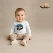 Babybody für Jungen in Weiß mit Motiv „Rookie Saison“, getragen von einem Kind – Wunderknirps.