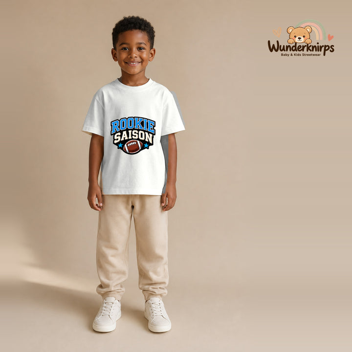 T-Shirt für Jungen in Weiß mit Motiv „Rookie Saison“, getragen von einem Kind – Wunderknirps.