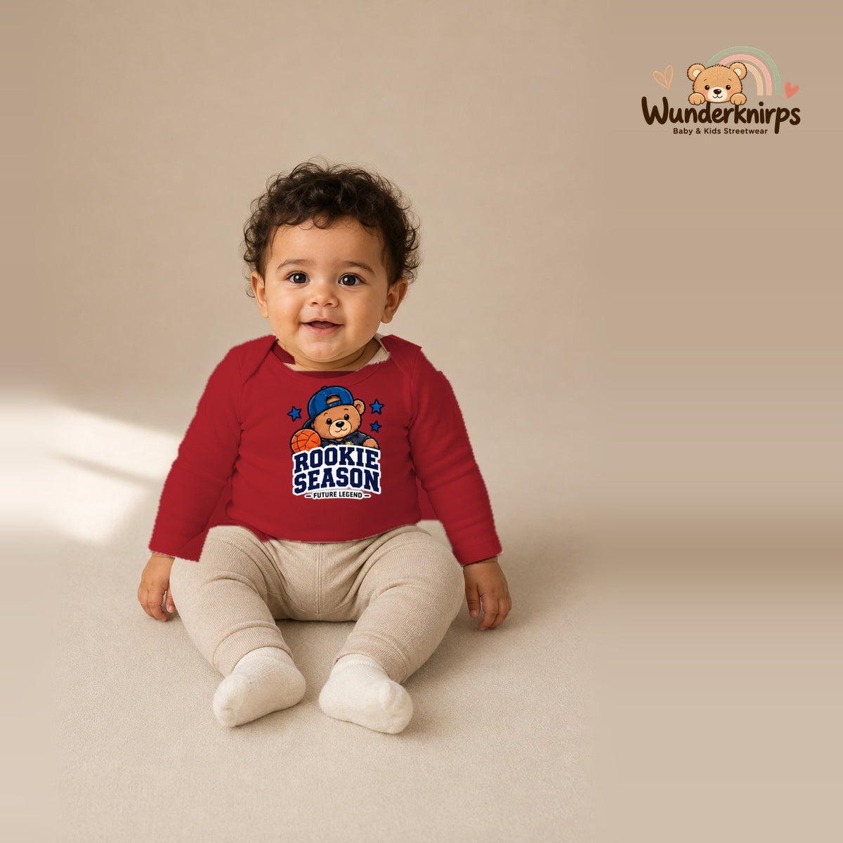 Babybody für Jungen in Rot mit Motiv „Rookie Season“, getragen von einem Kind – Wunderknirps.