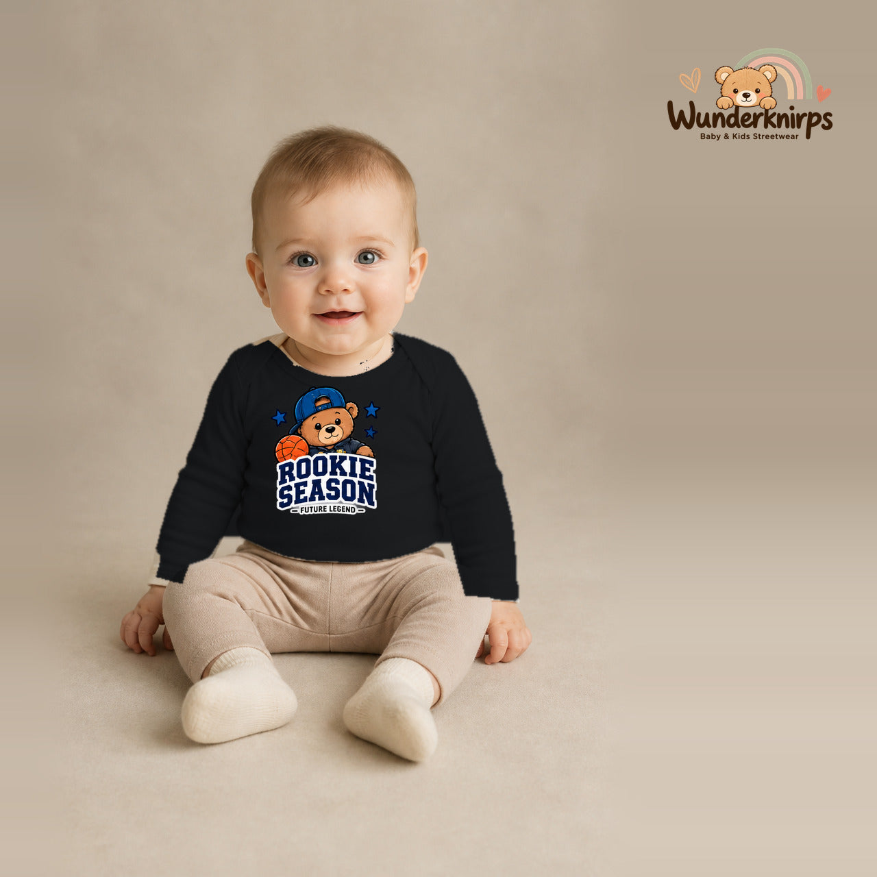 Babybody für Jungen in Schwarz mit Motiv „Rookie Season“, getragen von einem Kind – Wunderknirps.