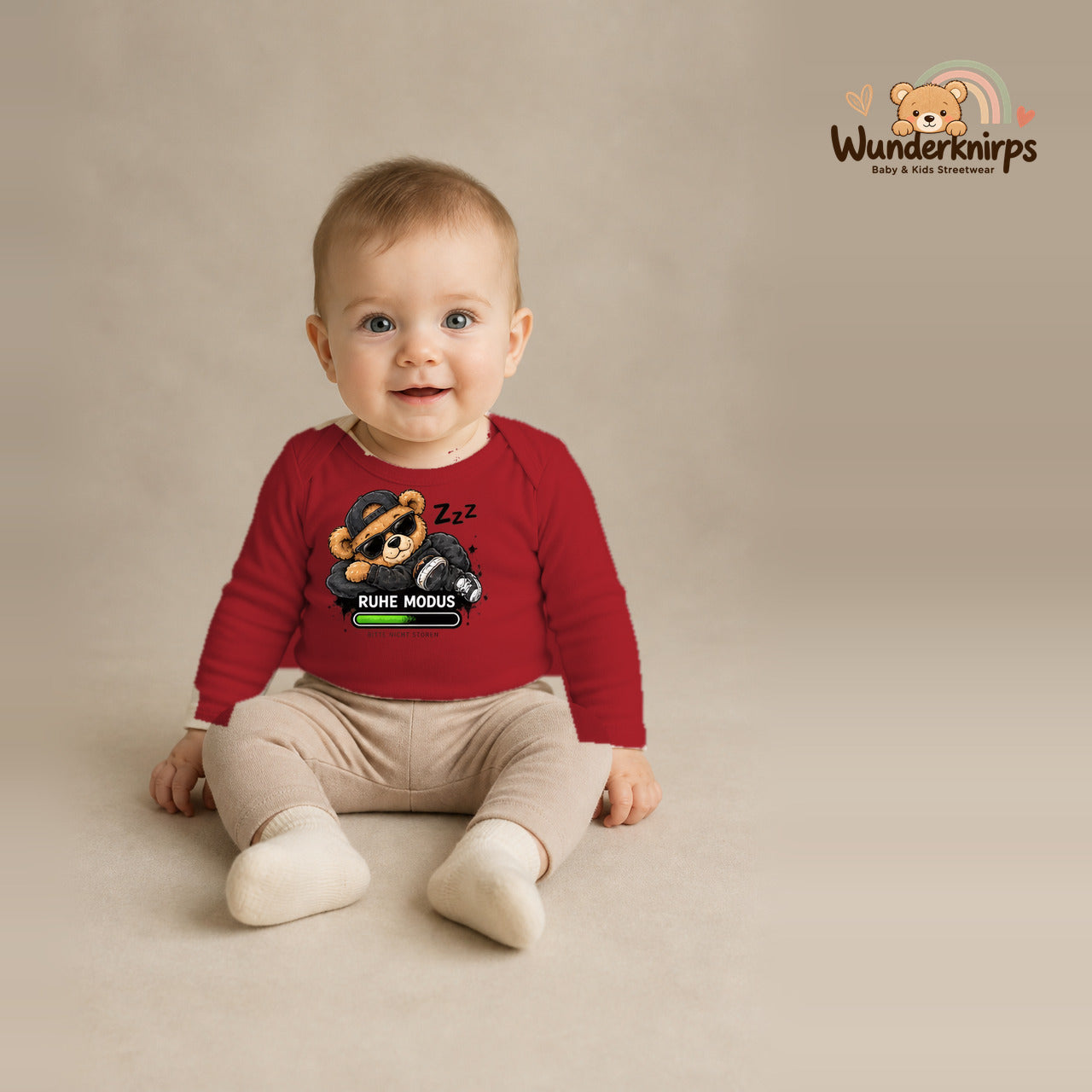 Babybody für Jungen in Rot mit Motiv „Ruhemodus“, getragen von einem Kind – Wunderknirps.