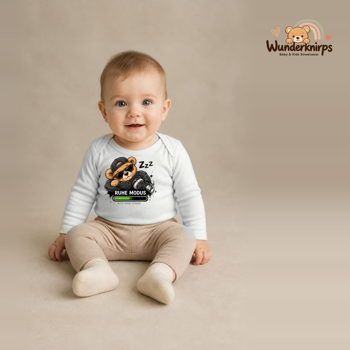 Babybody für Jungen in Weiß mit Motiv „Ruhemodus“, getragen von einem Kind – Wunderknirps.