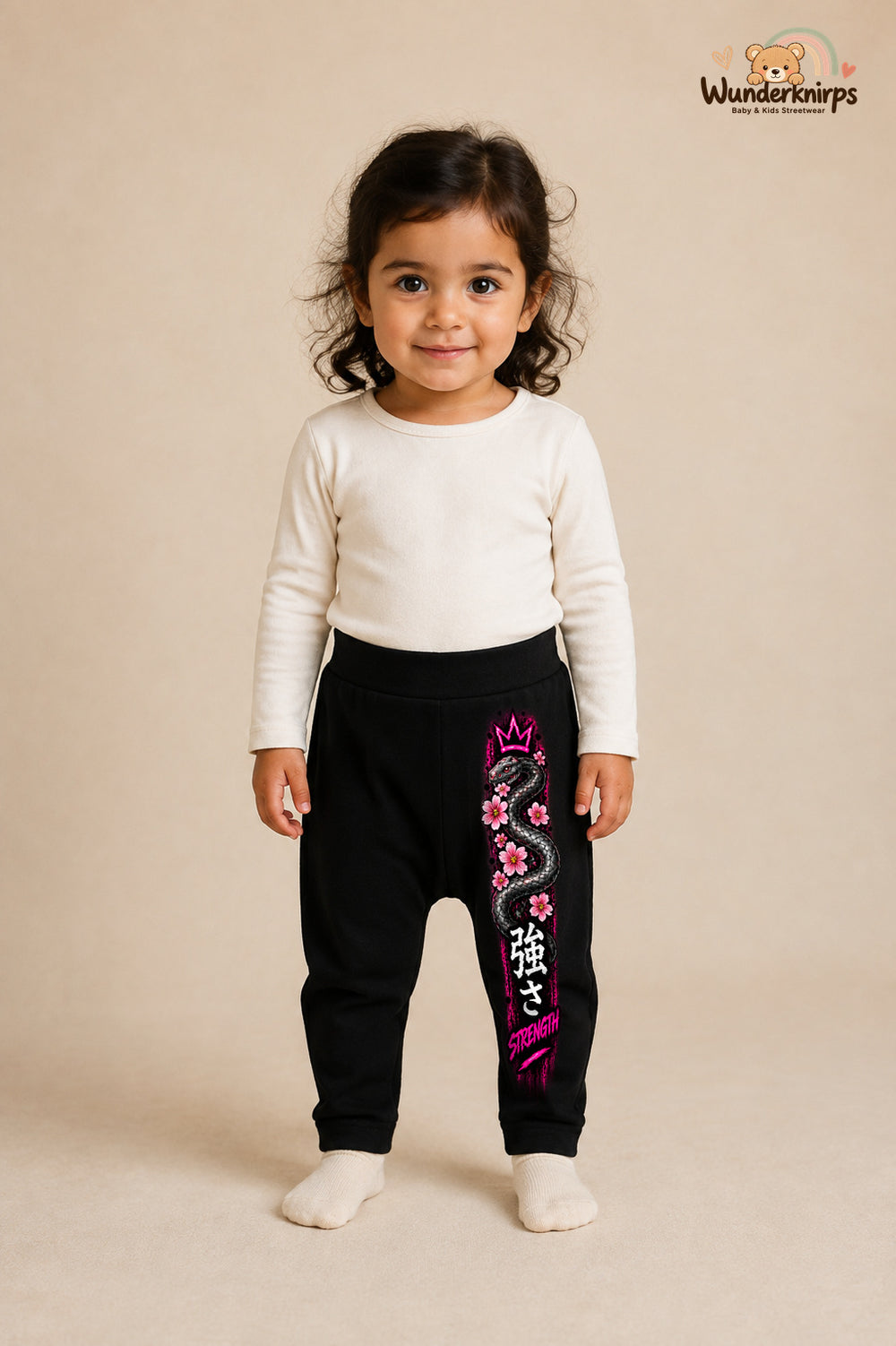 Schlange Traumlook – Strength – Babyhose für Mädchen: Schwarz mit Schlange-Druck am Hosenbein – Wunderknirps.