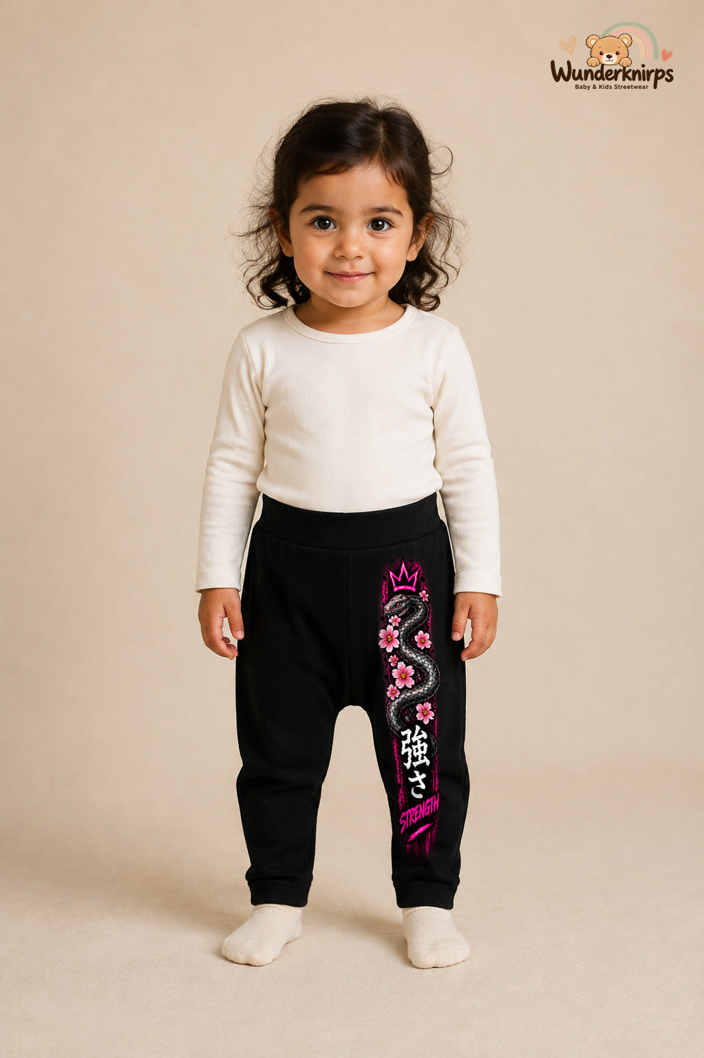 Schlange Traumlook – Strength – Babyhose für Mädchen: Schwarz mit Schlange-Druck am Hosenbein – Wunderknirps.