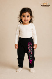 Schlange Traumlook – Strength – Babyhose für Mädchen: Schwarz mit Schlange-Druck am Hosenbein – Wunderknirps.