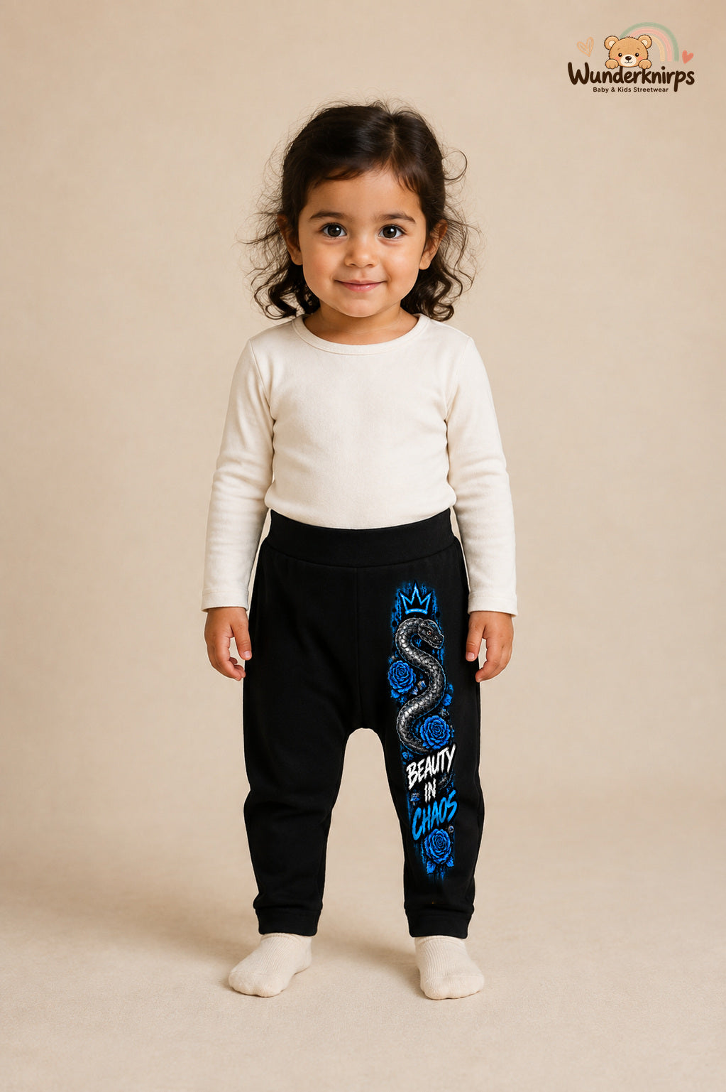 Kleine Weltentdeckerin: Beauty in chaos – Babyhose für Mädchen: Schwarz mit Schlange-Druck am Hosenbein – Wunderknirps.