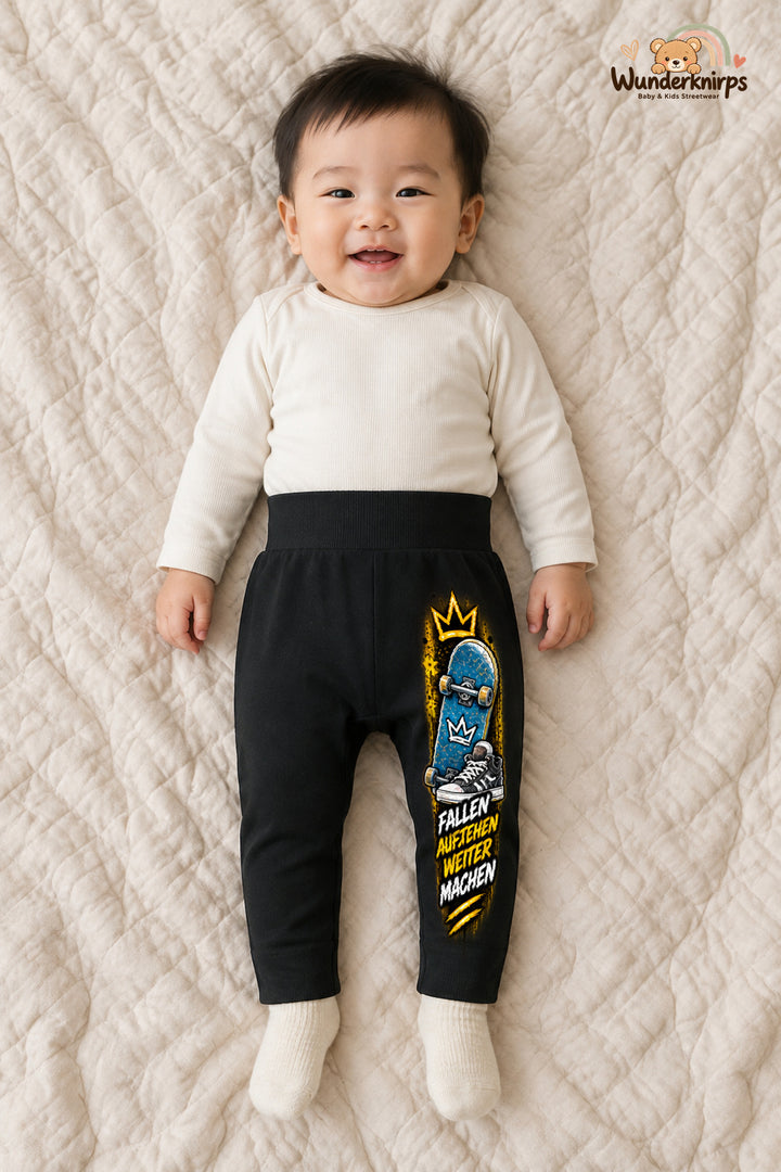 Skateboard Alltagsheld – Fallen aufstehen weitermachen – Babyhose für Jungen: Schwarz mit Skateboard-Druck am Hosenbein – Wunderknirps.