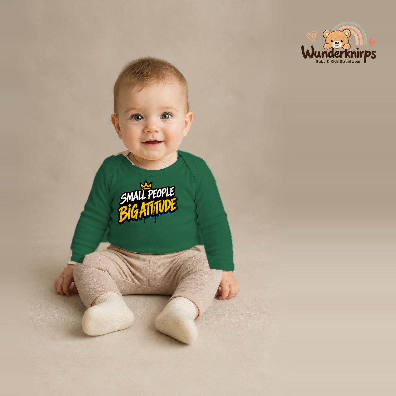 Babybody für Jungen in Grün mit Motiv „Small People Big Attitude“, getragen von einem Kind – Wunderknirps.