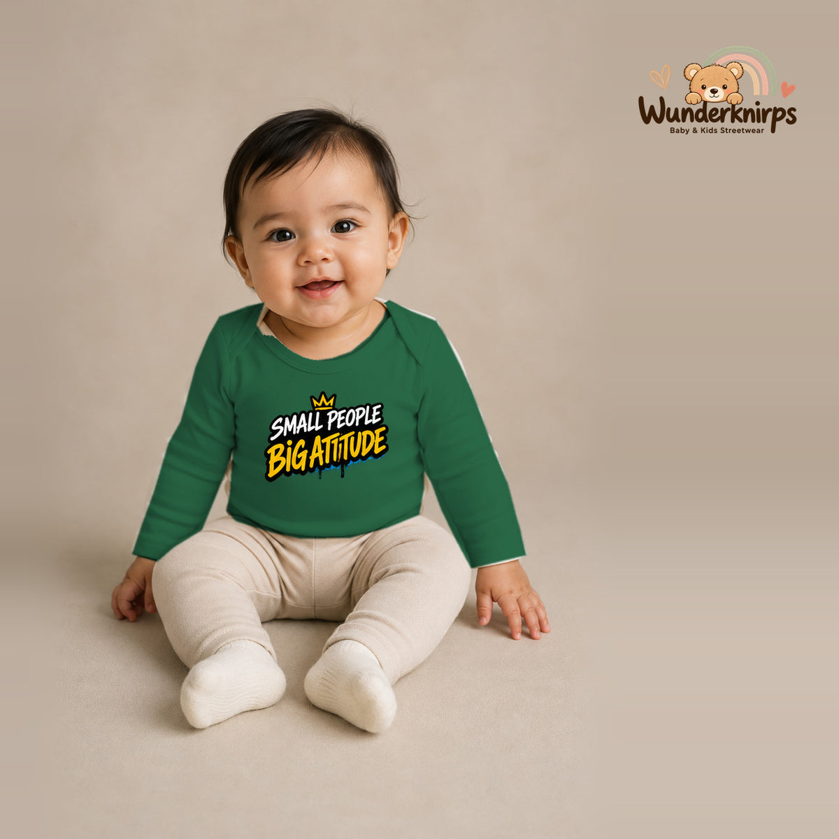 Babybody für Mädchen in Grün mit Motiv „Small People Big Attitude“, getragen von einem Kind – Wunderknirps.