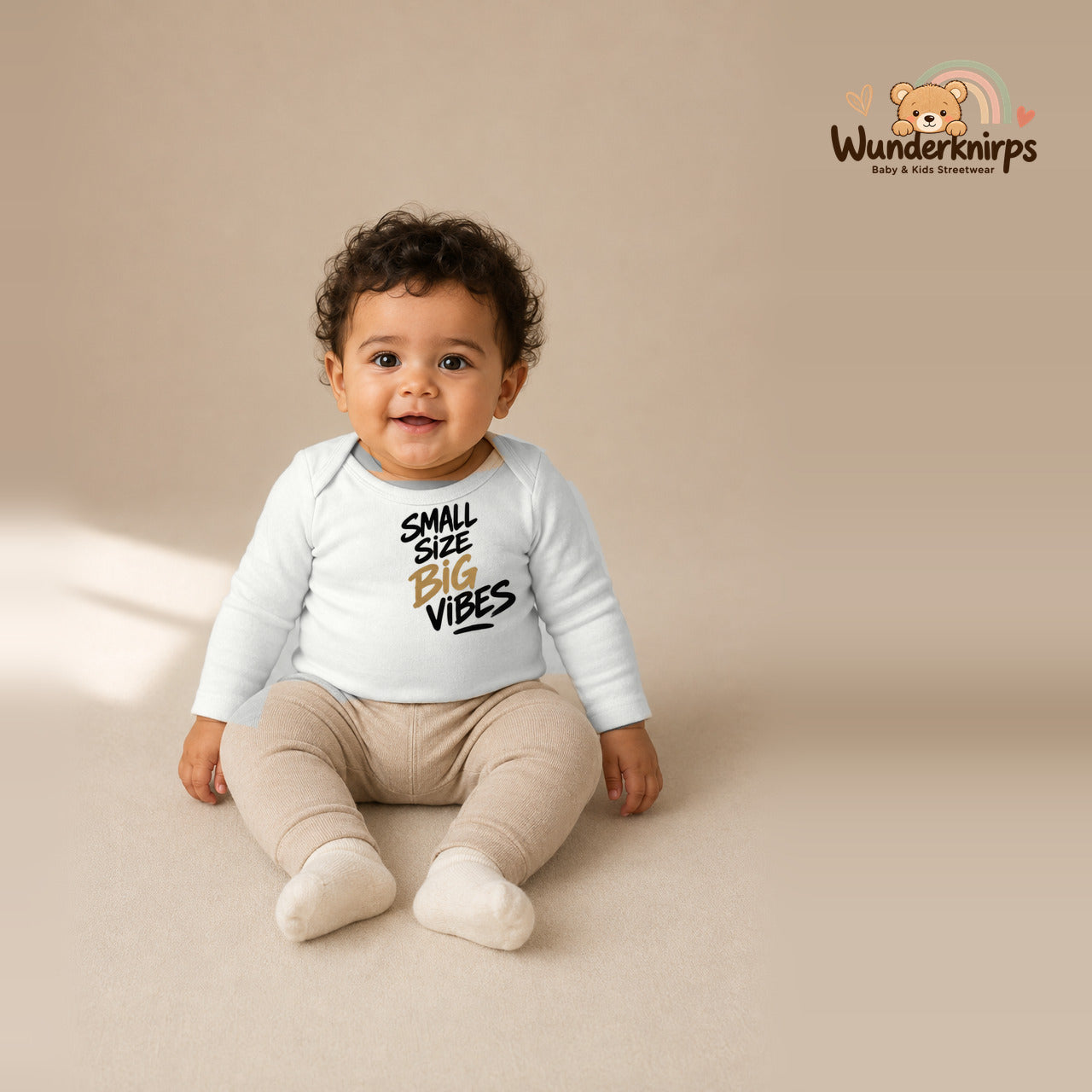 Babybody für Jungen in Weiß mit Motiv „Small Size Big Vibes“, getragen von einem Kind – Wunderknirps.