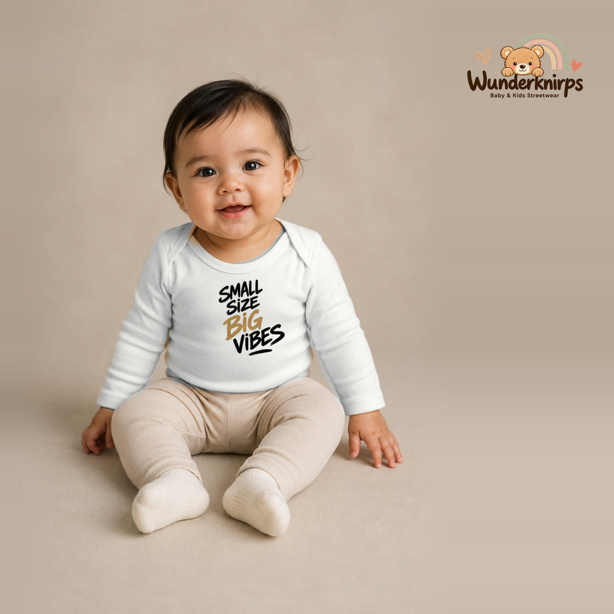 Babybody für Mädchen in Weiß mit Motiv „Small Size Big Vibes“, getragen von einem Kind – Wunderknirps.