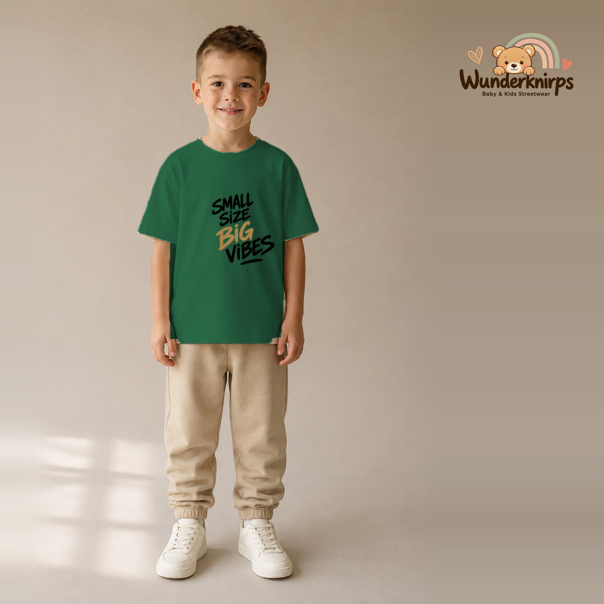 T-Shirt für Jungen in Grün mit Motiv „Small Size Big Vibes“, getragen von einem Kind – Wunderknirps.
