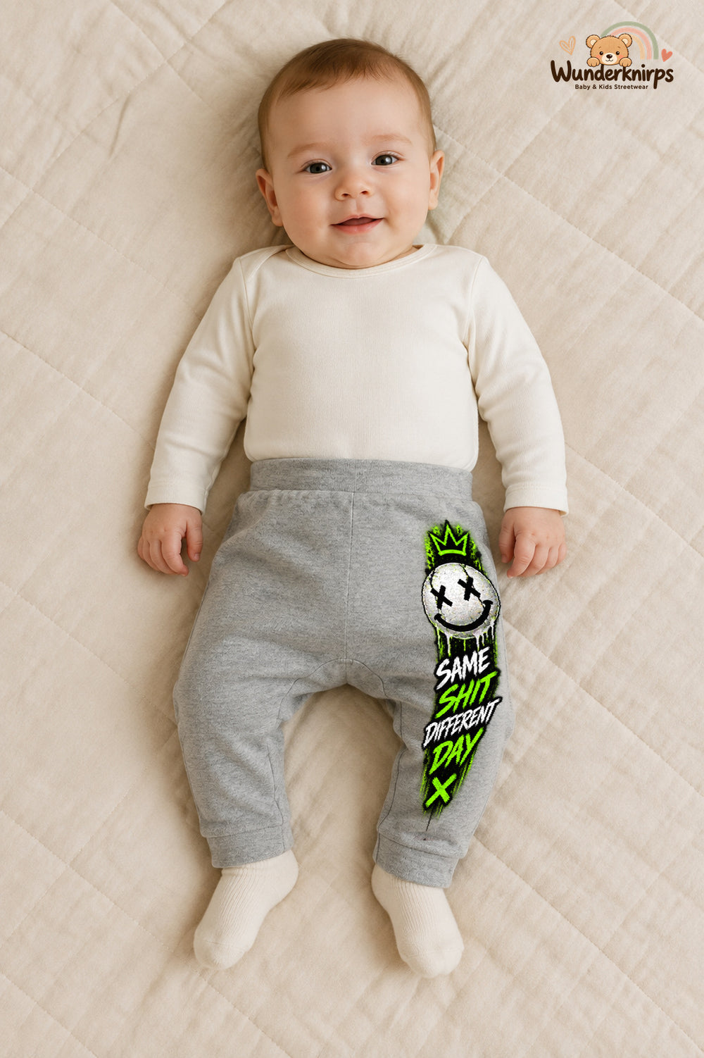 Same shit different day – Babyhose mit dem Motiv Smiley – für Jungen: Grau meliert mit Smiley-Druck am Hosenbein – Wunderknirps.