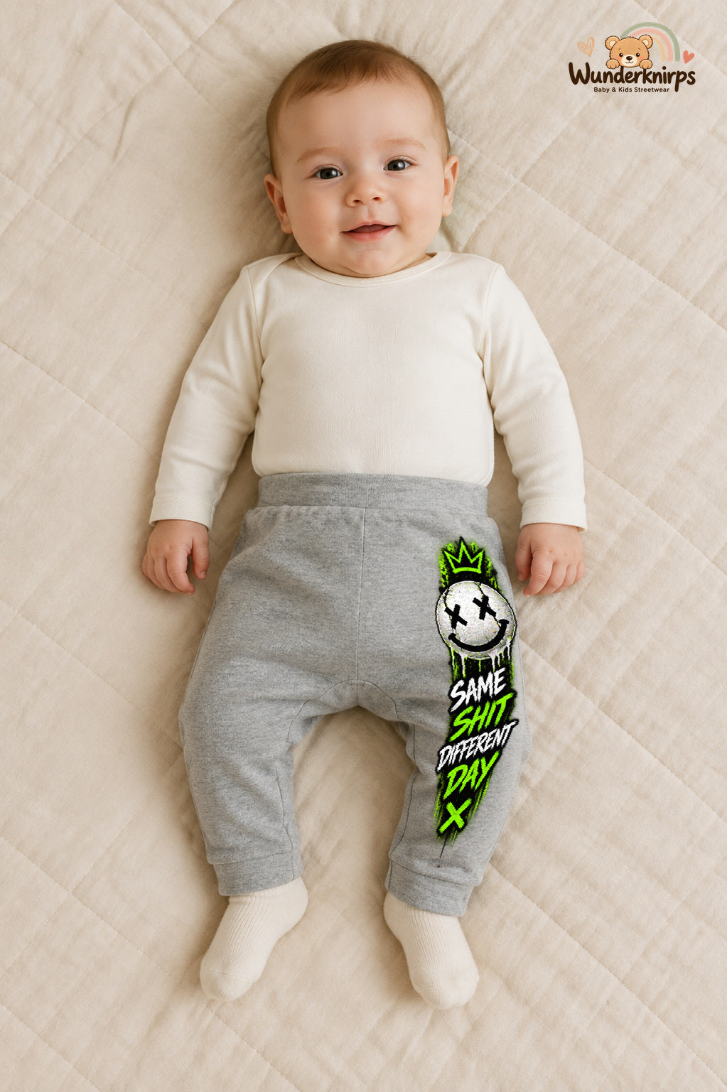 Same shit different day – Babyhose mit dem Motiv Smiley – für Jungen: Grau meliert mit Smiley-Druck am Hosenbein – Wunderknirps.