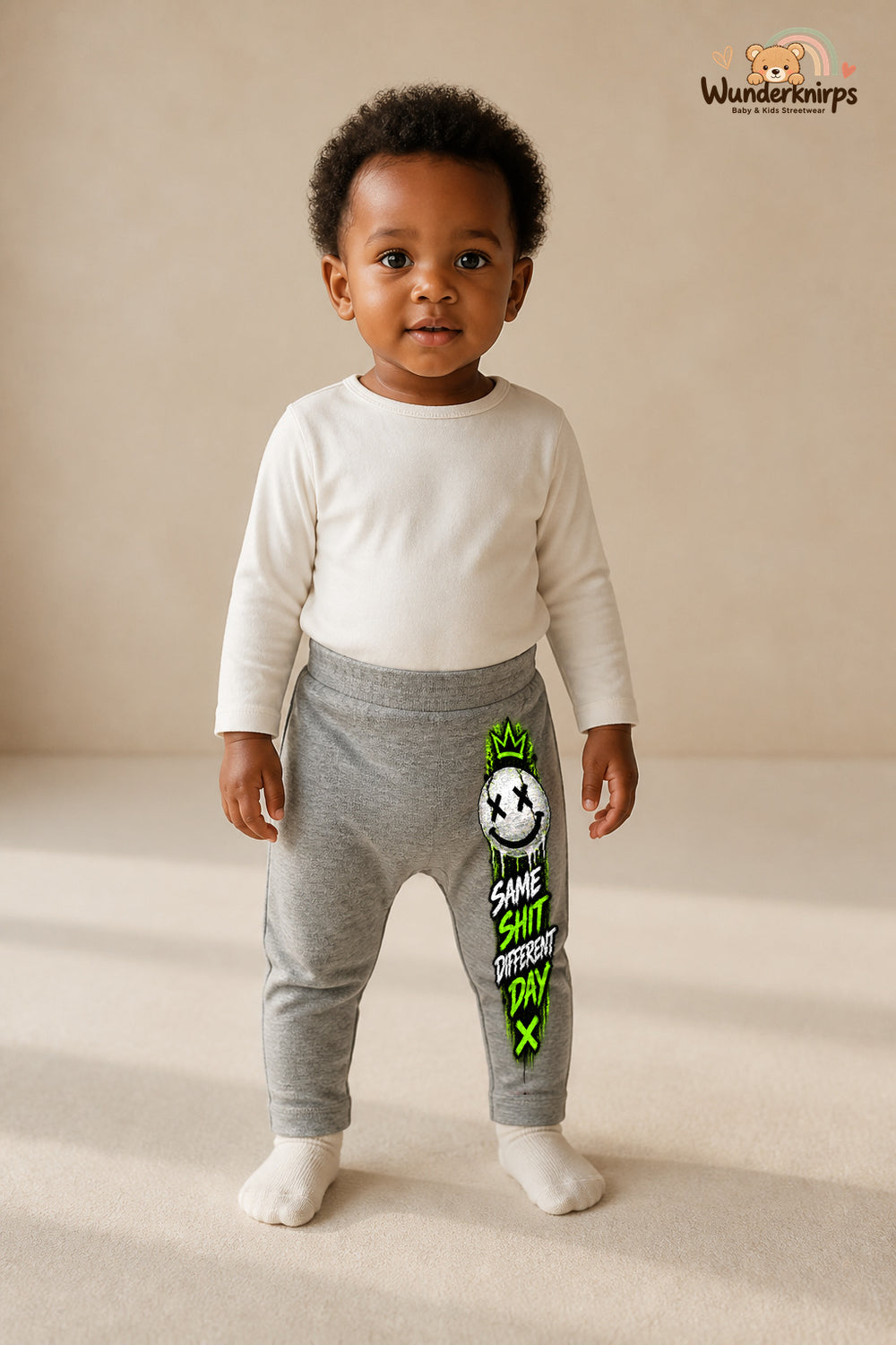 Smiley Lieblingslook – Same shit different day – Babyhose für Mädchen: Grau meliert mit Smiley-Druck am Hosenbein – Wunderknirps.
