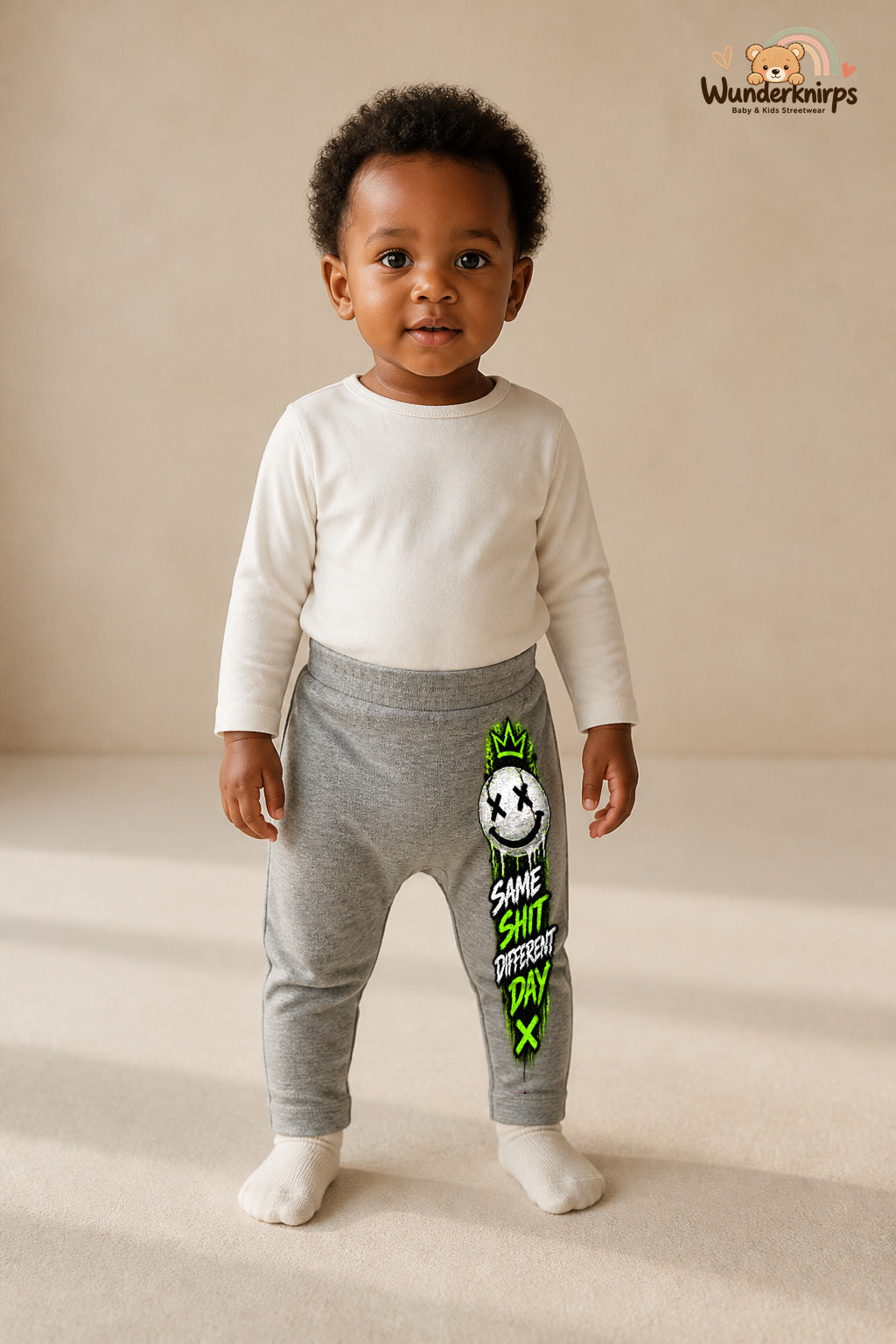 Smiley Lieblingslook – Same shit different day – Babyhose für Mädchen: Grau meliert mit Smiley-Druck am Hosenbein – Wunderknirps.