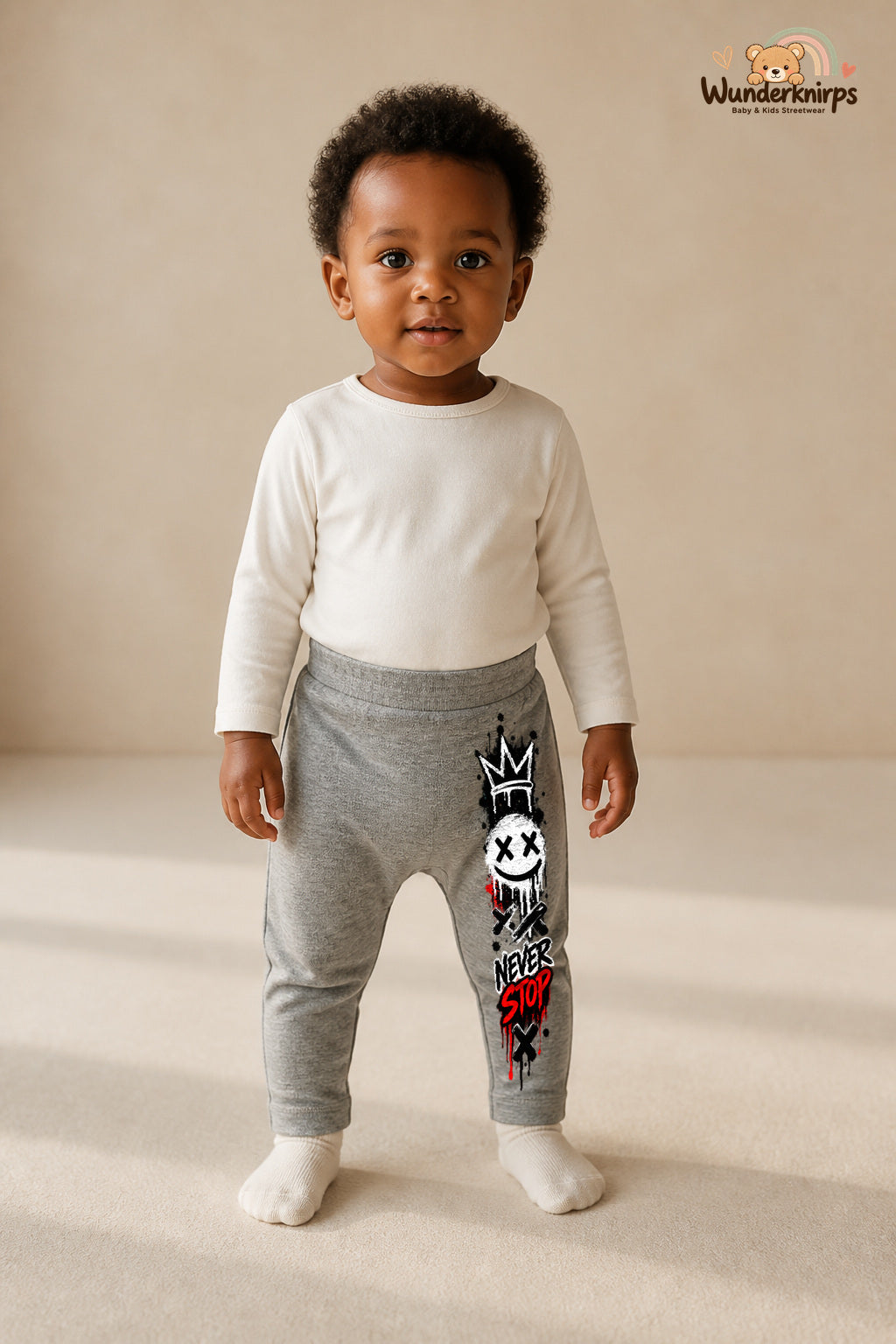 Kleine Weltentdeckerin: Never stop – Babyhose für Mädchen: Grau meliert mit Smiley-Druck am Hosenbein – Wunderknirps.