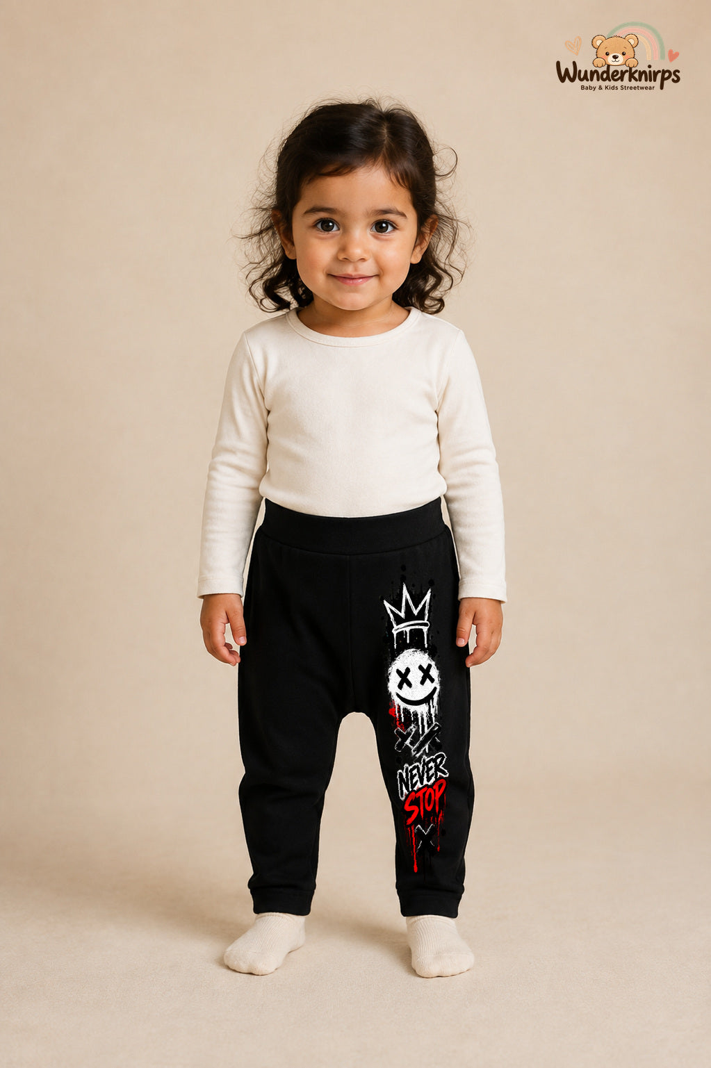Kleine Weltentdeckerin: Never stop – Babyhose für Mädchen: Schwarz mit Smiley-Druck am Hosenbein – Wunderknirps.