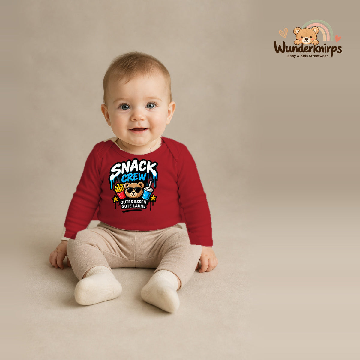 Babybody für Jungen in Rot mit Motiv „Snack Crew“, getragen von einem Kind – Wunderknirps.