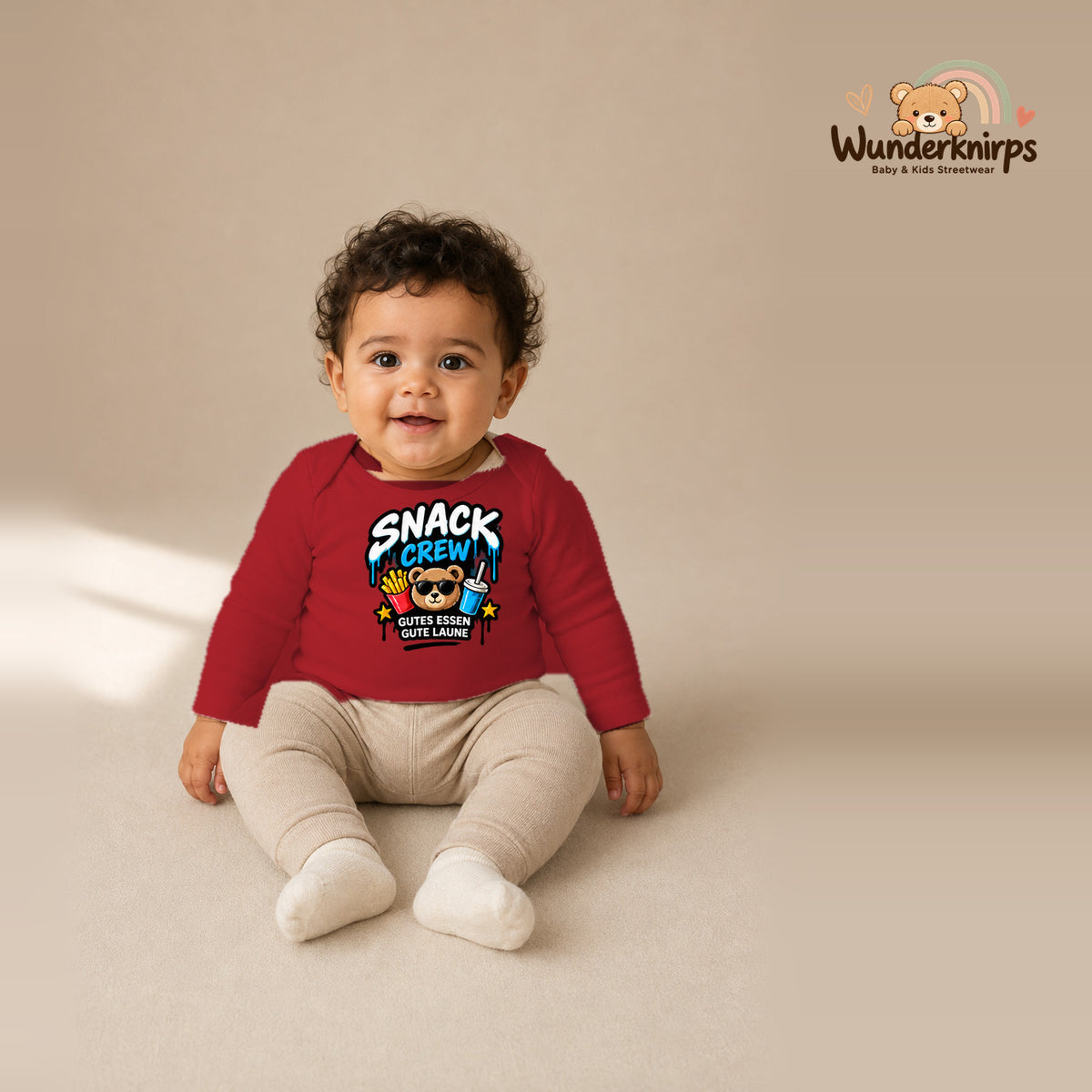 Babybody für Jungen in Rot mit Motiv „Snack Crew“, getragen von einem Kind – Wunderknirps.