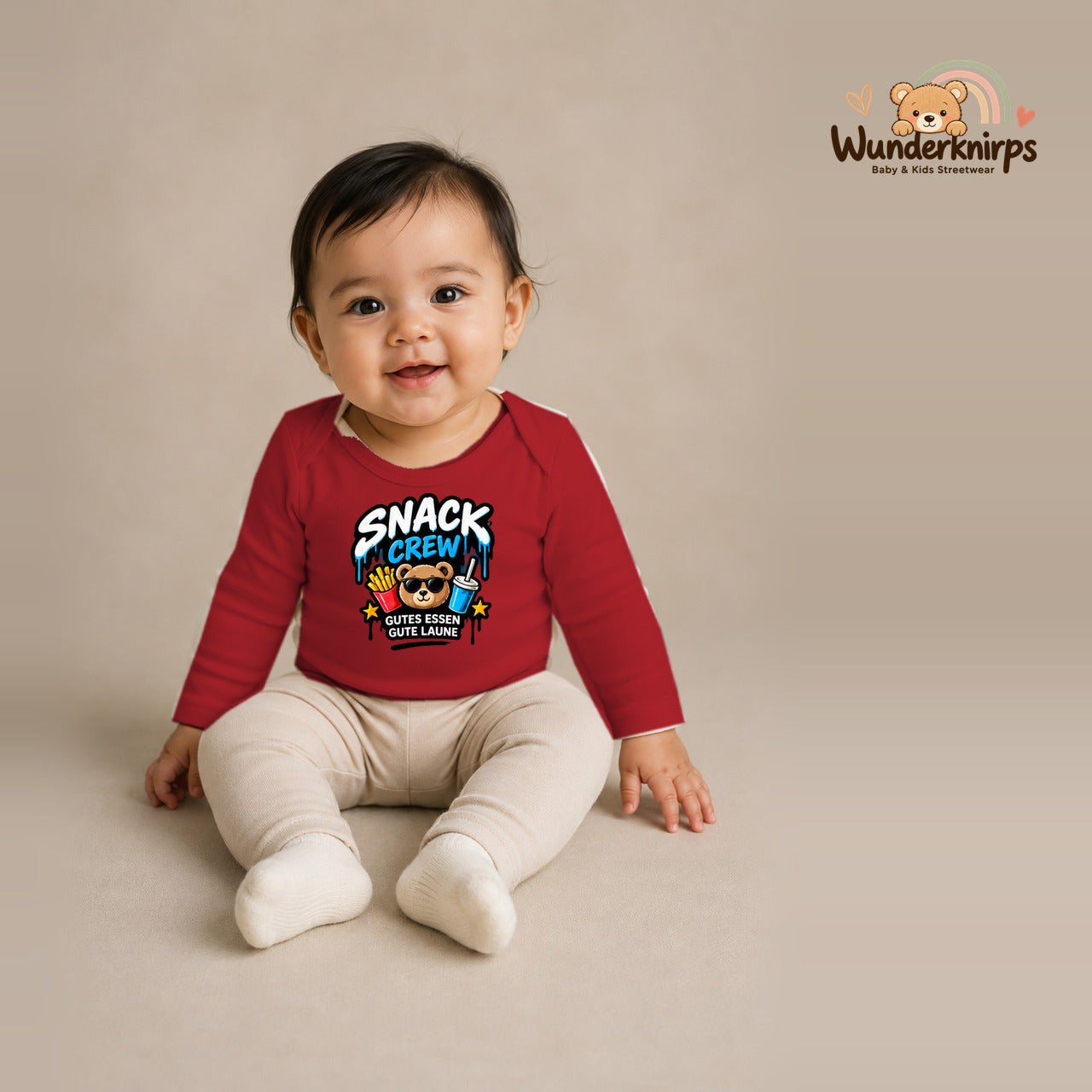 Babybody für Mädchen in Rot mit Motiv „Snack Crew“, getragen von einem Kind – Wunderknirps.