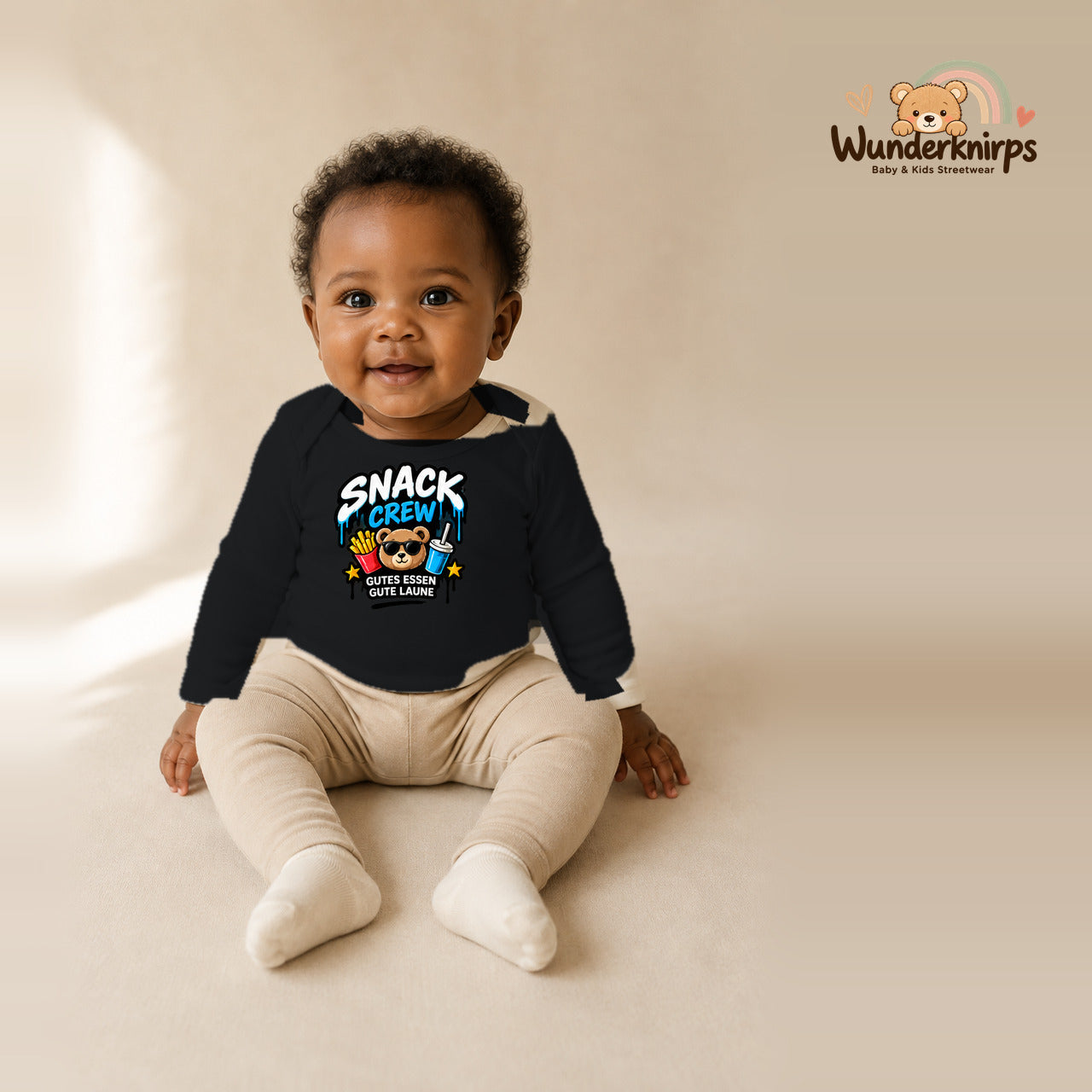 Babybody für Mädchen in Schwarz mit Motiv „Snack Crew“, getragen von einem Kind – Wunderknirps.