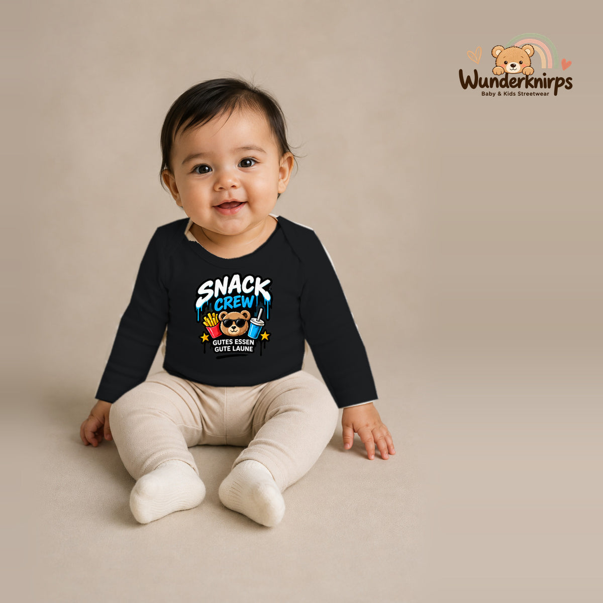 Babybody für Mädchen in Schwarz mit Motiv „Snack Crew“, getragen von einem Kind – Wunderknirps.