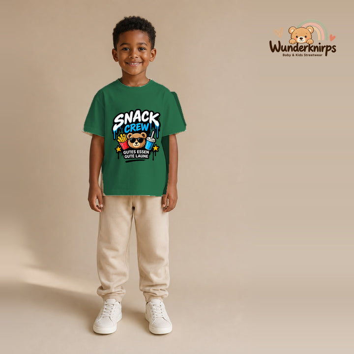 T-Shirt für Jungen in Grün mit Motiv „Snack Crew“, getragen von einem Kind – Wunderknirps.