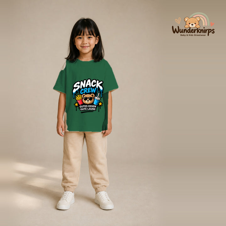 T-Shirt für Mädchen in Grün mit Motiv „Snack Crew“, getragen von einem Kind – Wunderknirps.